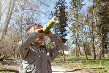 Boy looking at the kaleidoscope outdoors