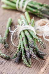 Bunch of organic green asparagus on an old wooden table
