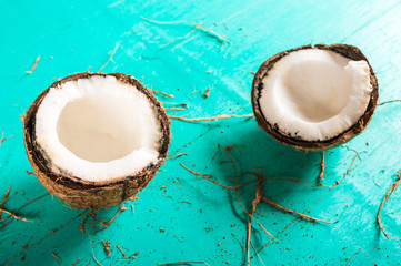 Halves of chopped coconut on a blue background with peel