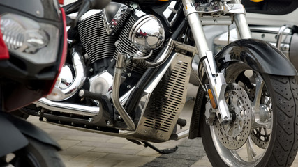 Shiny silver motorcycle with protective windshield standing outdoors, power