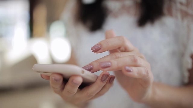 Closeup of young woman hands typing sms scrolling pictures phone