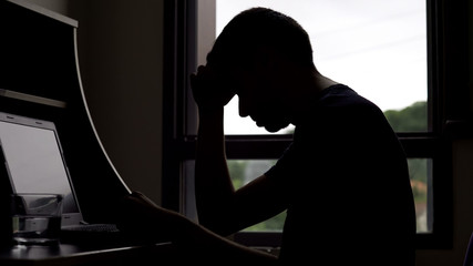 Lonely sad man looking for job online, unemployment and depression, problems
