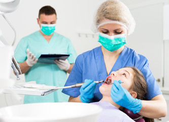 Female dentist with girl patient during oral checkup