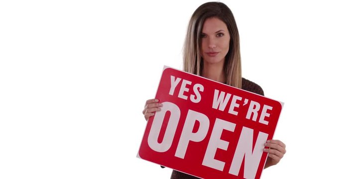Attractive woman holding Open sign on solid white copy space, Caucasian girl holding sign reading Yes We Are Open looking at camera standing on white background, 4k