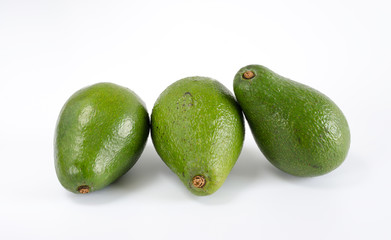 Whole avocados on white background.