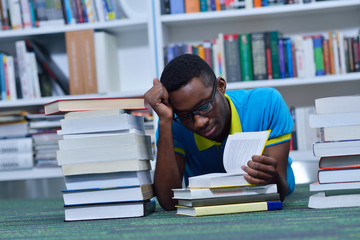 Male african american college student reading in library