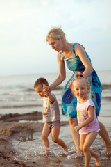 Fototapeta na wymiar Happy family playing on the beach