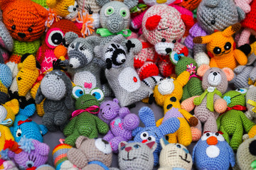 Fototapeta na wymiar Colorful handmade knitted dolls. Hobby & small business of women. Closeup. Showcase at the fair