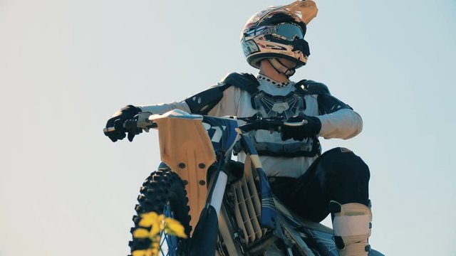 Equipped and prepared rider is sitting on his static motorcycle outdoors