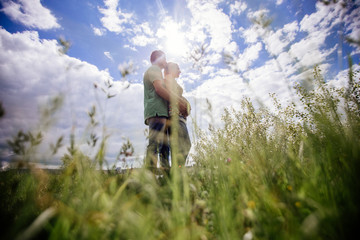 Couple standing in grass.