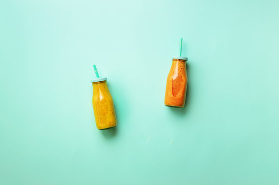 Fresh Orange, Banana, Pineapple, Mango Smoothies And Juicy Fruits On Blue Background. Detox Summer Drink. Vegetarian Concept. Top View, Flat Lay, Copy Space