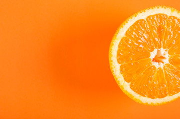 Top view of a half orange fruit on an orange colored background