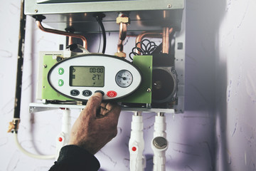 Engineer adjusting thermostat for efficient automated heating system