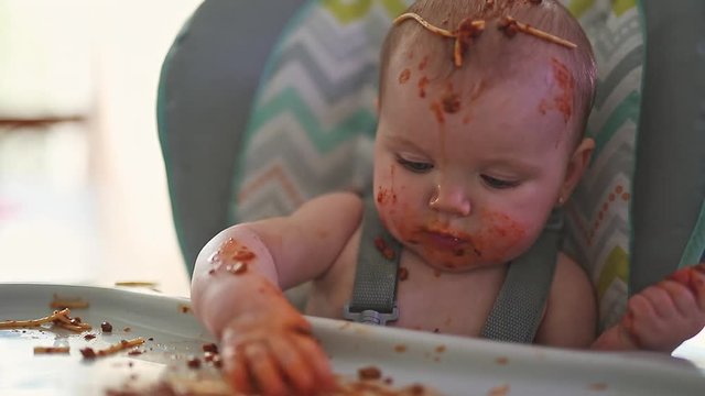 Little baby eating her dinner and making a mess