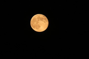 Full yellow moon in black sky background at the night