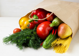 A paper bag with fresh vegetables and fruit.