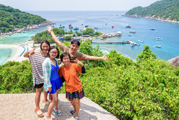 Fototapeta premium Thai family tourists is posing happily on top of the Koh Nang Yuan island is a high viewpoint and beautiful natural landscape is a famous attractions in the Gulf of Thailand, Surat Thani, Thailand