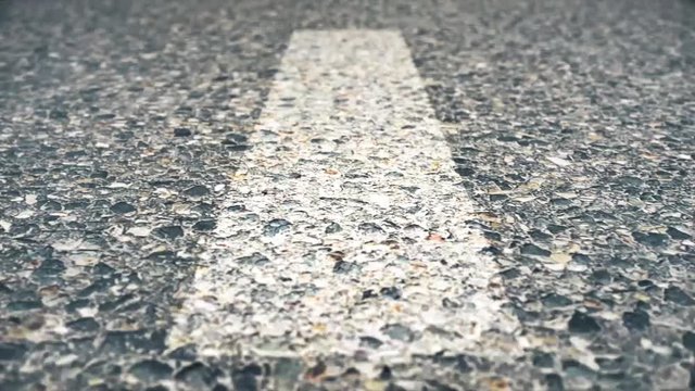 Line On The Road, Close-up, Fast movement. Speed road flight, seamlessly loop-able. Close up of road, asphalt, white arrow signs indicating direction, way, of the highway. Urban traffic flow, pulse.