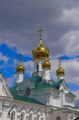 Fototapeta na wymiar Beatiful golden domes of orthodox church on a background of overcast sky.
