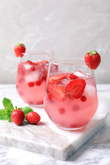 Glasses of natural lemonade with berries on table
