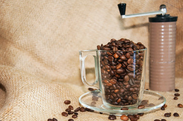 coffee beans in a cup and a hand grinder