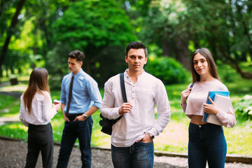 Two young Students talking in front of friends in the University in campus