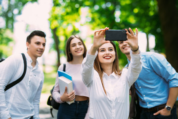 Pretty young friends students take selfie on mobile phone at campus