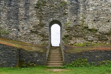 Arch with stairway in large brick wall of old medieval castle   