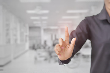 The woman touches the imaginary screen with her finger. Background blur emergency room