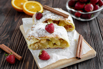 Homemade strudel with apples on a wooden background