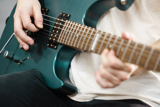 Close up of man playing on electric guitar
