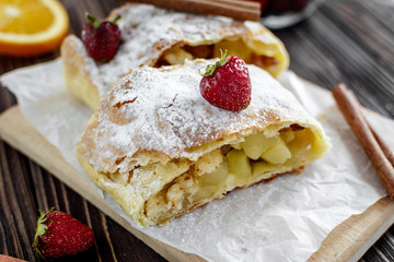 Homemade strudel with apples on a wooden background