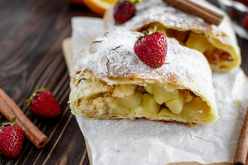 Homemade strudel with apples on a wooden background