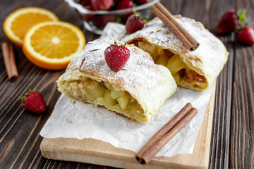 Homemade strudel with apples on a wooden background
