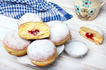 Traditional Polish donuts on wooden background.  Tasty doughnuts with jam.