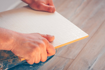 Obraz premium Worker breaks the cut tile on a curved line by hand