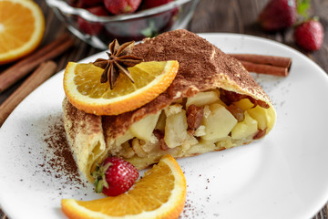 Homemade strudel with apples on a wooden background