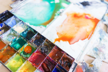 Abstract background concept for school watercolor. Hobbies and education, a cuvette with different watercolors. 