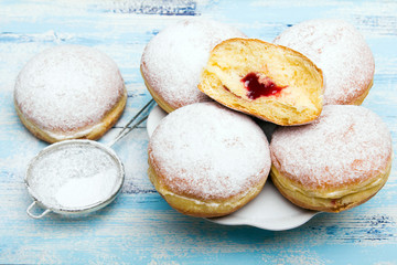 Traditional Polish donuts on wooden background.  Tasty doughnuts with jam.
