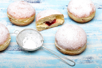 Traditional Polish donuts on wooden background.  Tasty doughnuts with jam.