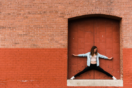 beautiful young woman standing in doorway on big building