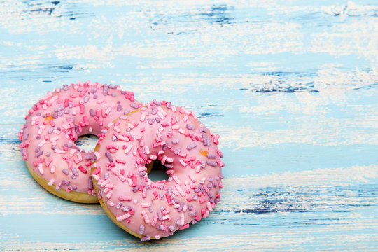 Traditional donuts on blue wooden background.  Tasty doughnuts with icing, copy space