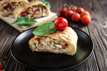 Homemade strudel with meat on a wooden background