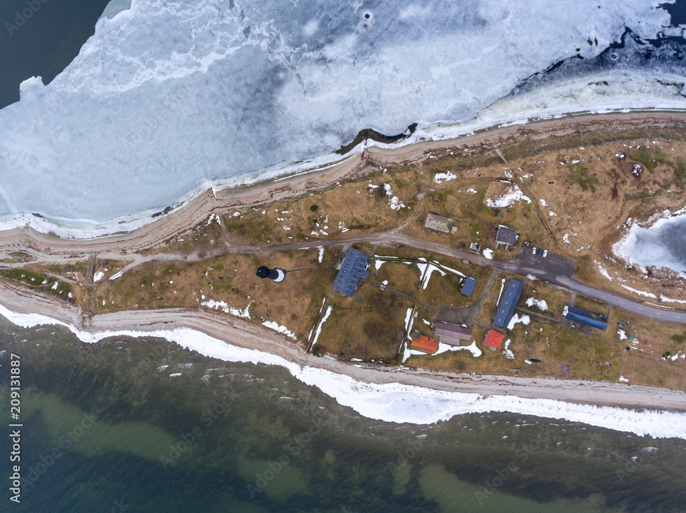 Wall mural top view at sorve peninsula with buildings and lighthouse. baltic sea at spring season. saaremaa, es