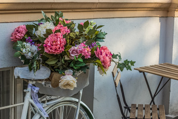 Fototapeta na wymiar soft focus vintage cycle with flowers concept near cafe interior object with inscription on ribbon 
