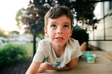 boy looking up while laying on belly