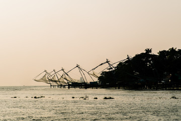 Silhouette of chinese fishing nets in fort kochi during sunset.