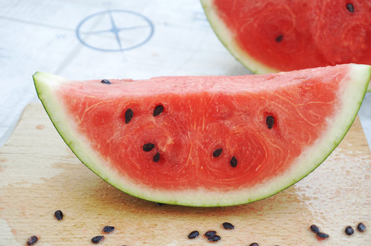 Ripe and juicy slice of watermelon on the wooden kitchen board