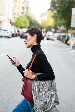 Stylish short haired business woman commuting between meetings on a busy city