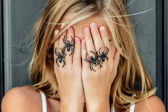 Girl posing with fake spiders
